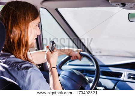 Talking while drive auto walkie talkie comunication concept. Young man driving car using cb radio