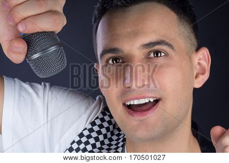 Young Male Black-haired Pop Singer Performs With Microphone