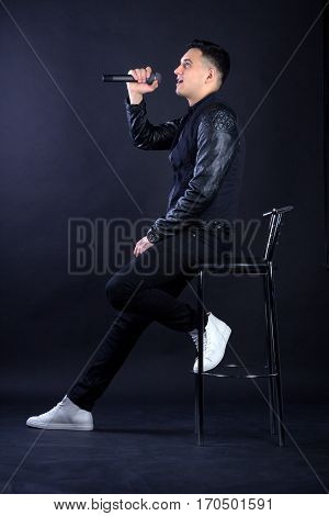 Young Male Black-haired Pop Singer Singing To Microphone