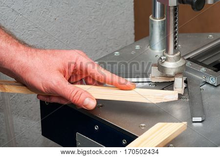 Craftsman working on frame in frame shop. Professional framer hand holding frame angle. Top view.