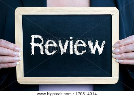 Review - businesswoman holding chalkboard with text