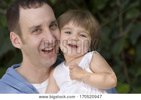 Loving father and his daughter hugging outside.