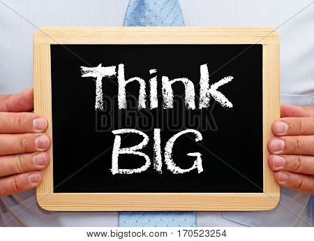Think BIG - Businessman holding chalkboard with text