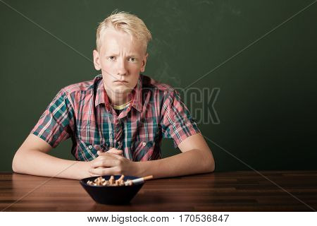 Frowning Defiant Teenage Boy With Cigarettes