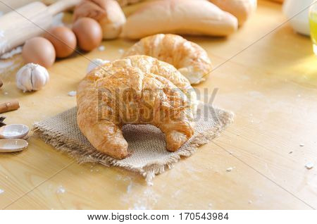 Close up shot of Croissant and bekery ingredients on wooden table