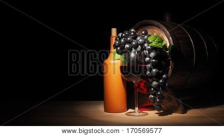 Glass Of Red Wine And Barrel On Wooden Table