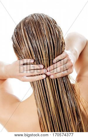Photo of woman applying hair conditioner.