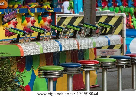LAWRENCEVILLE, GA - SEPTEMBER 2016: Empty stools and squirt guns await contestants at a game at the Gwinnett County Fair in Lawrenceville GA on September 17 2016.