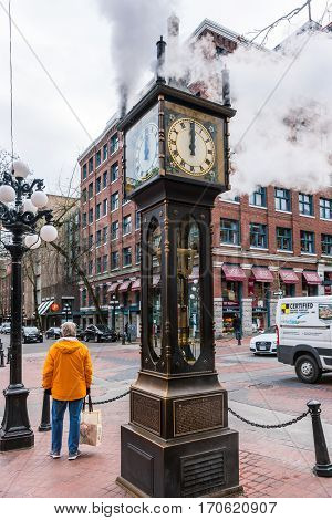 Vancouver Canada - January 28 2017: The historic steam clock strikes midday in Gastown downtown Vancouver with jets of steam rising from the clock.