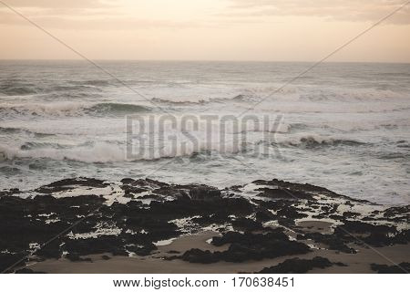 Waves crashing on the shore at sunset. Oregon USA.