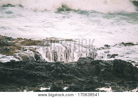 Waves crashing on the shore at sunset. Thor's Well Cape Perpetua Oregon USA.
