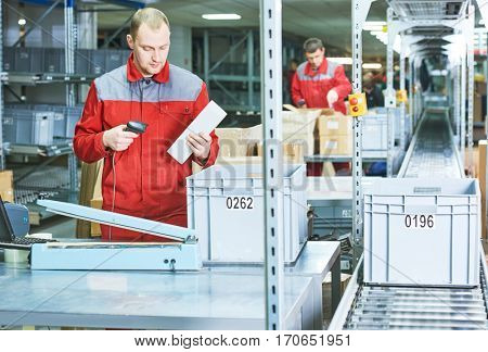 worker with laser barcode scanner at warehouse