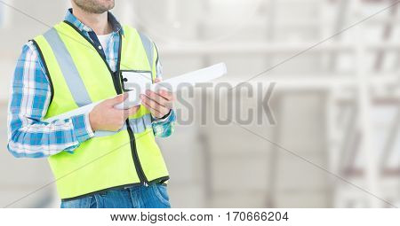 Mid section of construction man standing with blue print