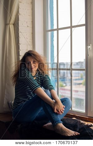 sitting on the window. redhead beautiful girl