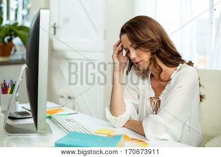 Frustrated businesswoman in front of computer at desk in office