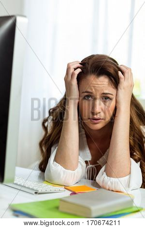 Portrait of frustrated businesswoman in front of computer at desk in office