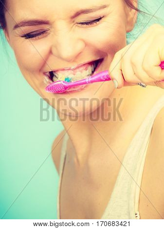 Woman brushing cleaning teeth. Girl with toothbrush. Oral hygiene. Bright green background