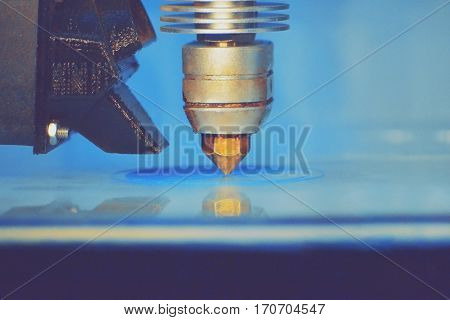 Modern 3D printer printing figure close-up macro.Automatic three dimensional 3d printer performs plastic blue colors modeling in laboratory. 3d-printing processing with white background