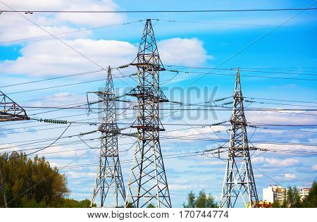 Electricity transmission pylons against blue sky. High voltage towers.