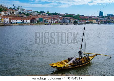 The iconic Rabelo boats, traditional Port wine transport on Douro river, with authentic Ribeira District view, Porto, Portugal.