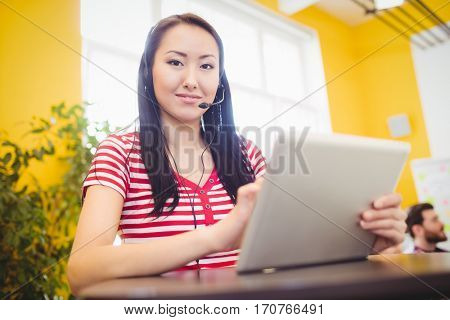 Portrait of appy young beautiful female executive using tablet at creative office