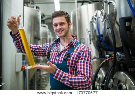 Portrait of brewer hydrometer cylinder at brewery factory