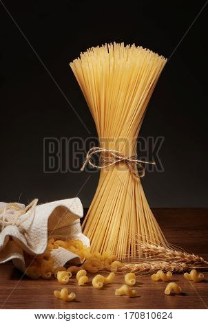 Dry Spaghetti, Cavatappi Pasta And Wheat Ears On Wooden Table