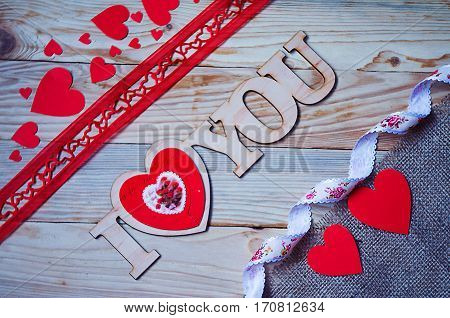 Hearts flowers ribbons on a wooden light background
