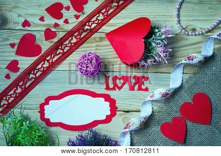 Hearts flowers ribbons on a wooden light background
