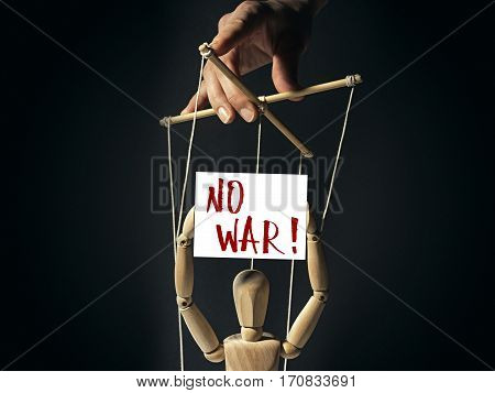 Tiran holds a puppet on strings in doll's hands a banner with inscription 