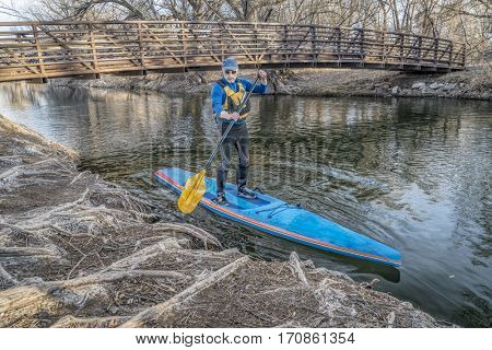 Stand up paddling on the Poudre RIver - a summer day like day in the middle of winter in northern Colorado