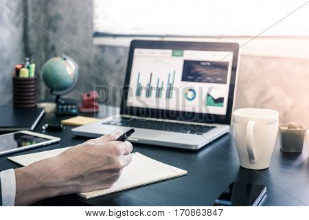 Businessman analyzing investment charts on the office desk.