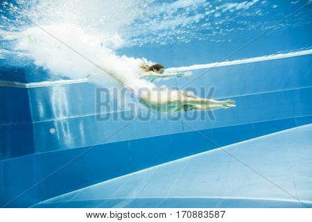 a young couple is jumping into the water from a diving plattform