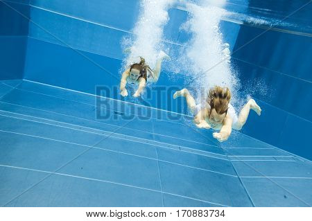 a young couple is jumping into the water from a diving plattform