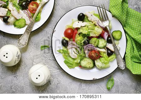 Vegetable Salad With Chicken And Black Olives On A White Plate.