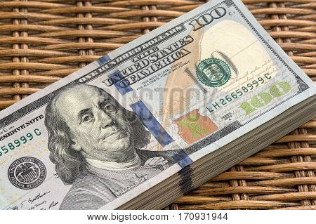 Stack of United States of America USD 100 One Hundred Dollars Federal Reserve Notes Pile on Wicker Background