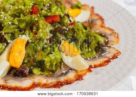 Salad with eel and vegetables. Very tasty food on a light background.