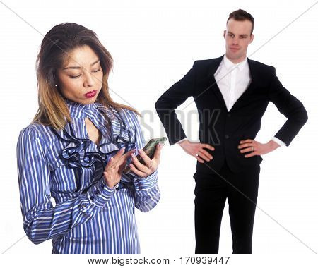 young woman with mobile phone texting while boss in black suit looks not amused