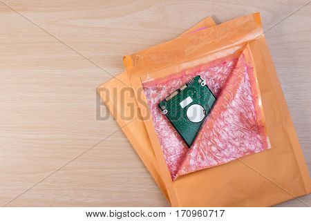 Used Yellow Blank Envelope With Transparent Bubble Wrap Or Packaging Shockproof On Wooden Table With