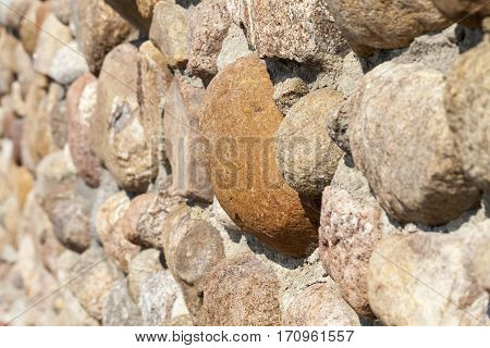 part of the wall of the new building made of large stones and small boulders. Photo taken closeup. Small depth of field.