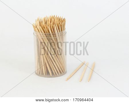 Many toothpicks in a clear plastic box on a white background.