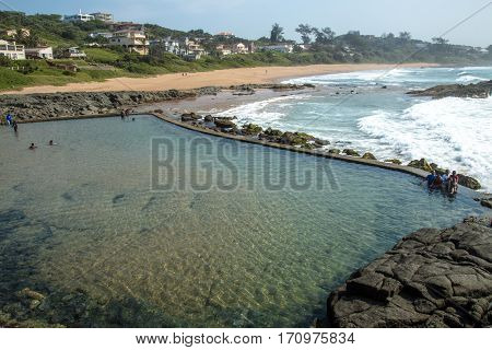 Tidal Pool Against Beach And Coastal Residential Buildings Landscape