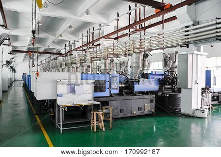 Row of plastic injection CNC machines at empty workshop