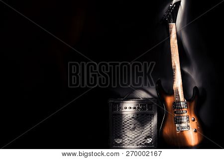 Electric Guitar And Amplifier On A Dark Background. Light Effect