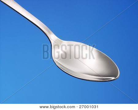 En teskefuld på blå baggrund.