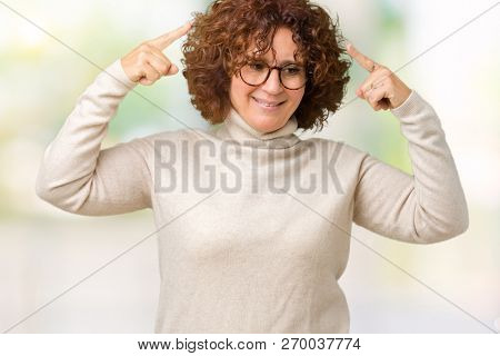Beautiful middle ager senior woman wearing turtleneck sweater and glasses over isolated background Smiling pointing to head with both hands finger, great idea or thought, good memory