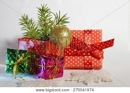 Gift Red Box In White Polka Dots With Bow Branches Christmas Tree Gifts Toy Ball On White Background
