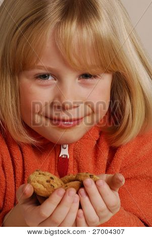 Little girl eating cookies,kid holding cookies.