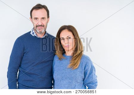 Beautiful middle age couple in love over isolated background Relaxed with serious expression on face. Simple and natural looking at the camera.