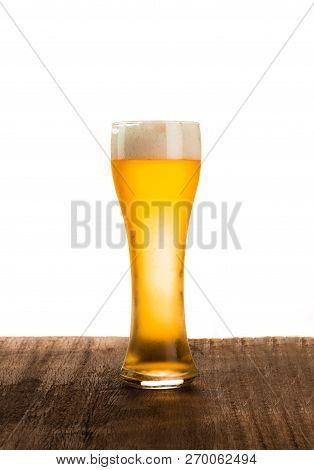 The Beer Glass Is Placed At A Wooden Table On  White Background
